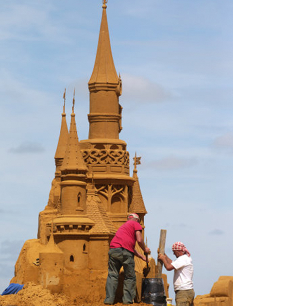 Artists work on their sand art piece during the sand sculpture festival. (Photo: PA Photos)