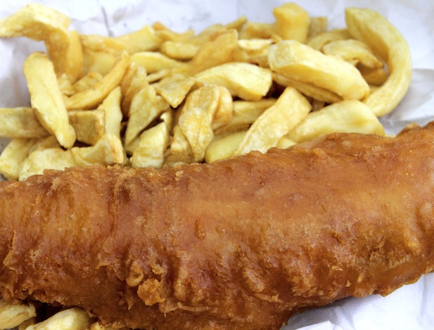 Portion of fish and chips on white paper