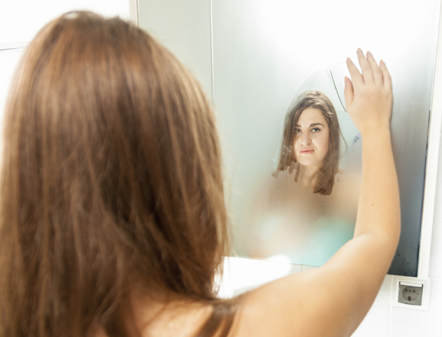 imge of a woman standing in front of a fogged up mirror