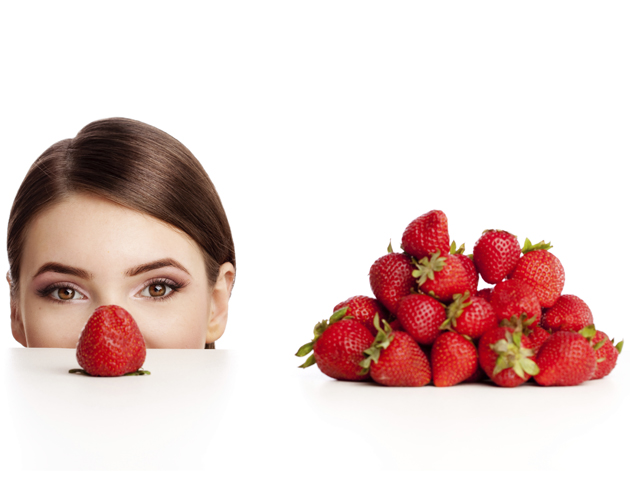 image of woman's face wiith a bowl of strawberries