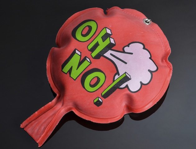 red rubber whoopee cushion with reflection on black glass