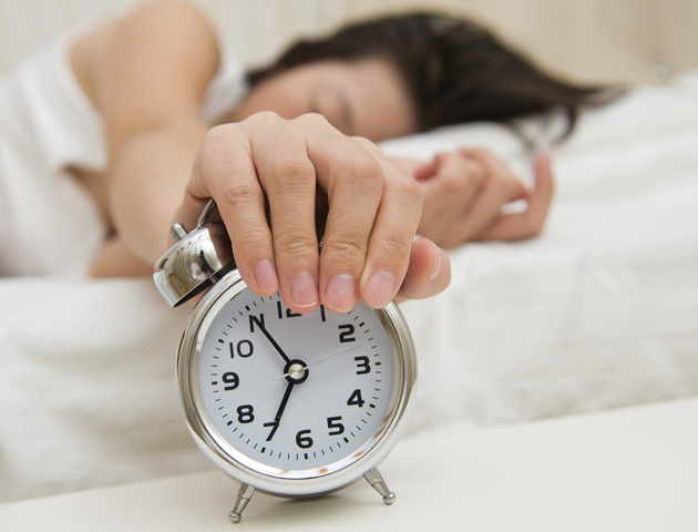 image of woman with hand out turning off an alarmclock