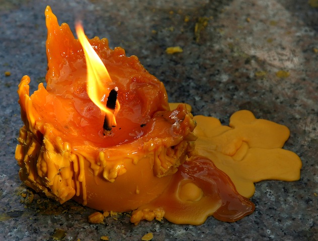 Yellow candle slowly burning down