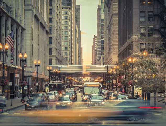 Chicago, United States- August 22, 2015: Blurred motion of the traffic downtown Chicago. We see the blur of the motion of the aerial train-metro in the background and cars in the foreground , while other vehicles are stop at traffic lights in downtown Chicago.