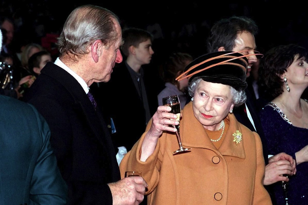 Toasting the year 2000, the Queen and Prince Philip celebrate the coming of the millennium with the crowds in London.