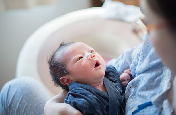 A newborn baby looking at its mum