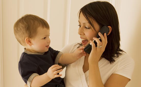 Mum talking on the phone while holding her son