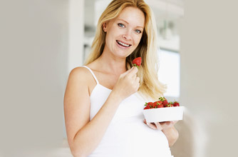 Pregnant woman eating strawberries