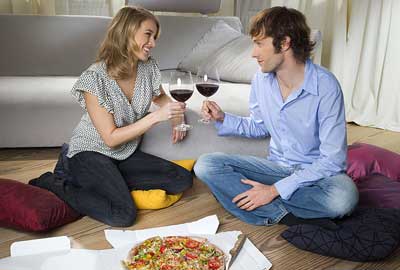 Couple eating pizza and drinking wine