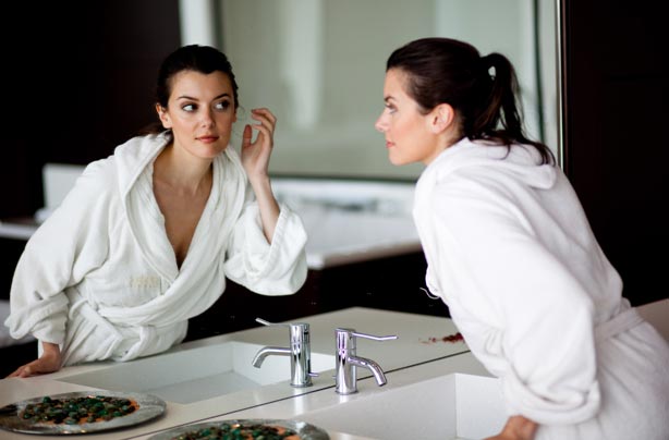 Woman in dressing gown looking in mirror