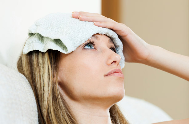 Woman with a wet flannel on her head