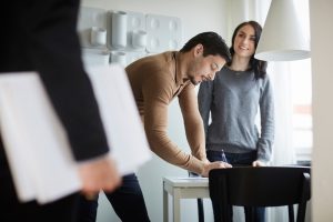 couple signing documents on the table for stamp duty