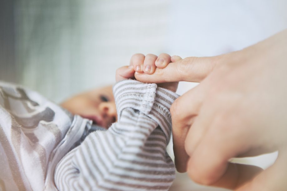 Baby holding mother's hand