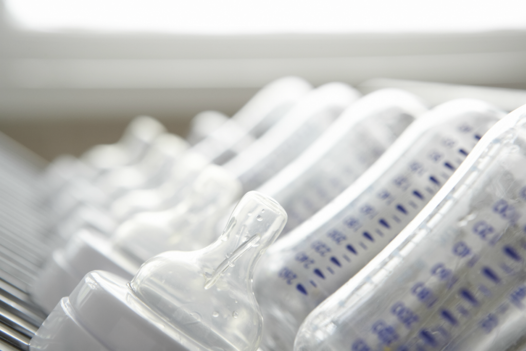 Baby's bottles on drying rack, close-up