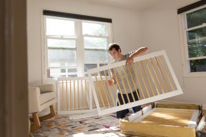 man pulling together a safe cot bed