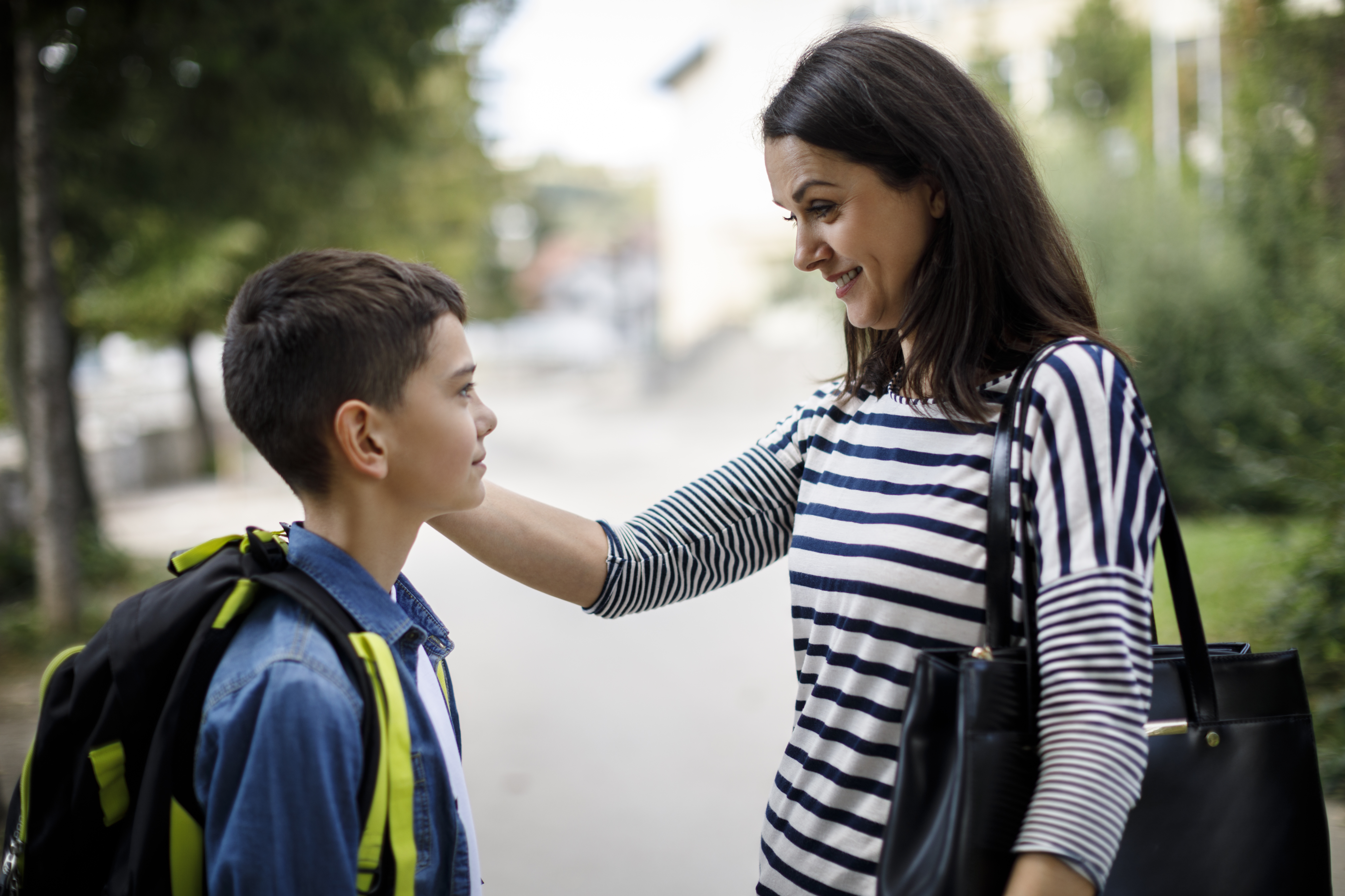 Mother meeting son in front of school.