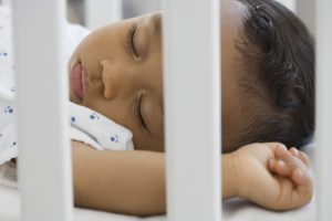 baby sleeping peacefully in a cot - controlled crying