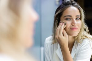 woman applying her make up with bio oil