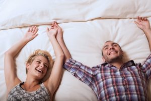 Couple lying in bed laughing