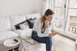 Young woman using phone to check for ovulation date