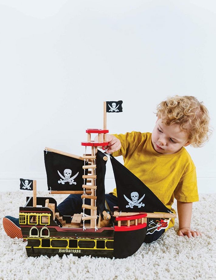 Child playing with toy wooden Pirate Ship
