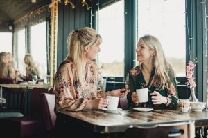 two women drinking at a cafe - part of the government's Eat Out to Help Out scheme