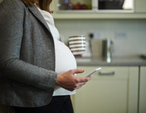 pregnant woman researching flu jab near me on phone