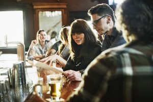 Two people look at a menu in a pub - 12 week government obesity plan 2020