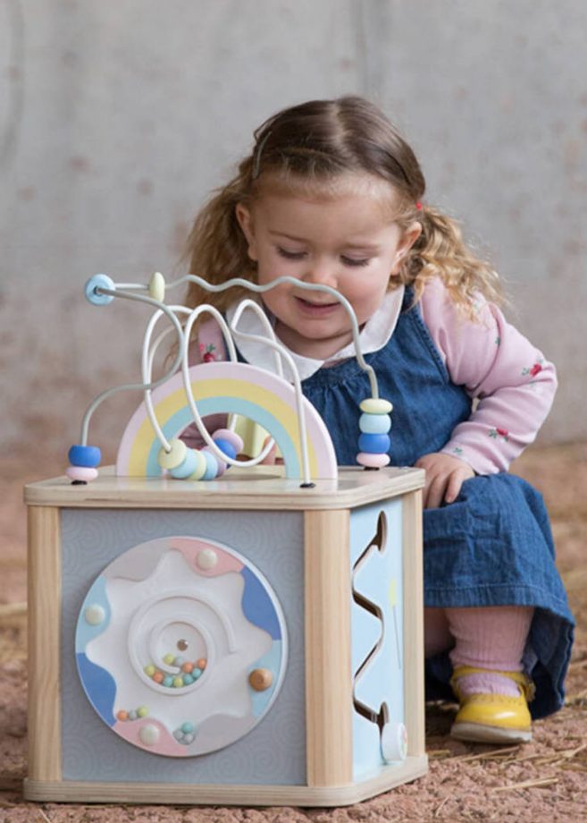A little girl playing with a toy for two year olds.