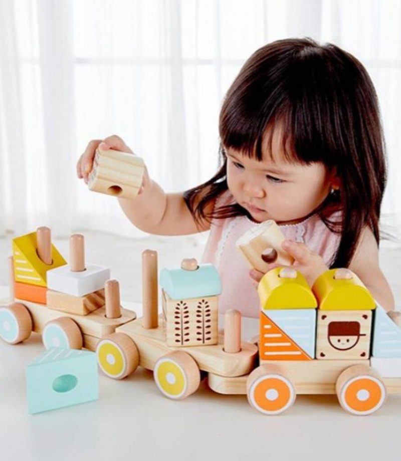 A little girl playing with a Pull Along Activity Train