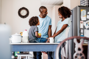 family in the kitchen with clock on the wall - teaching kids to tell time