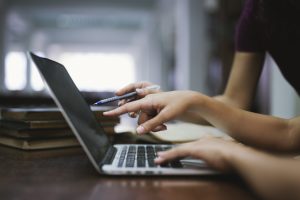 two people looking at a laptop screen - UCAS track results day