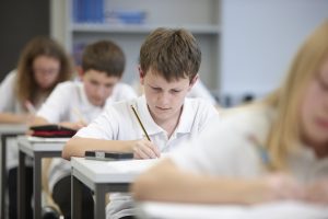 boy working at a desk - when do English schools go back