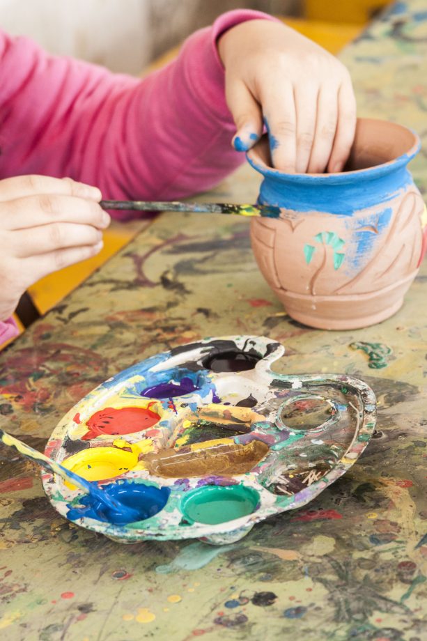 Child painting a vase.