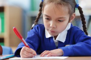young girl working at a desk - when do schools go back in england