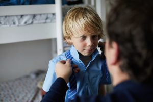 boy getting ready for school - school uniform government grant 2020