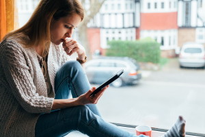 woman on tablet - fines imposed if you don't self isolate when told to