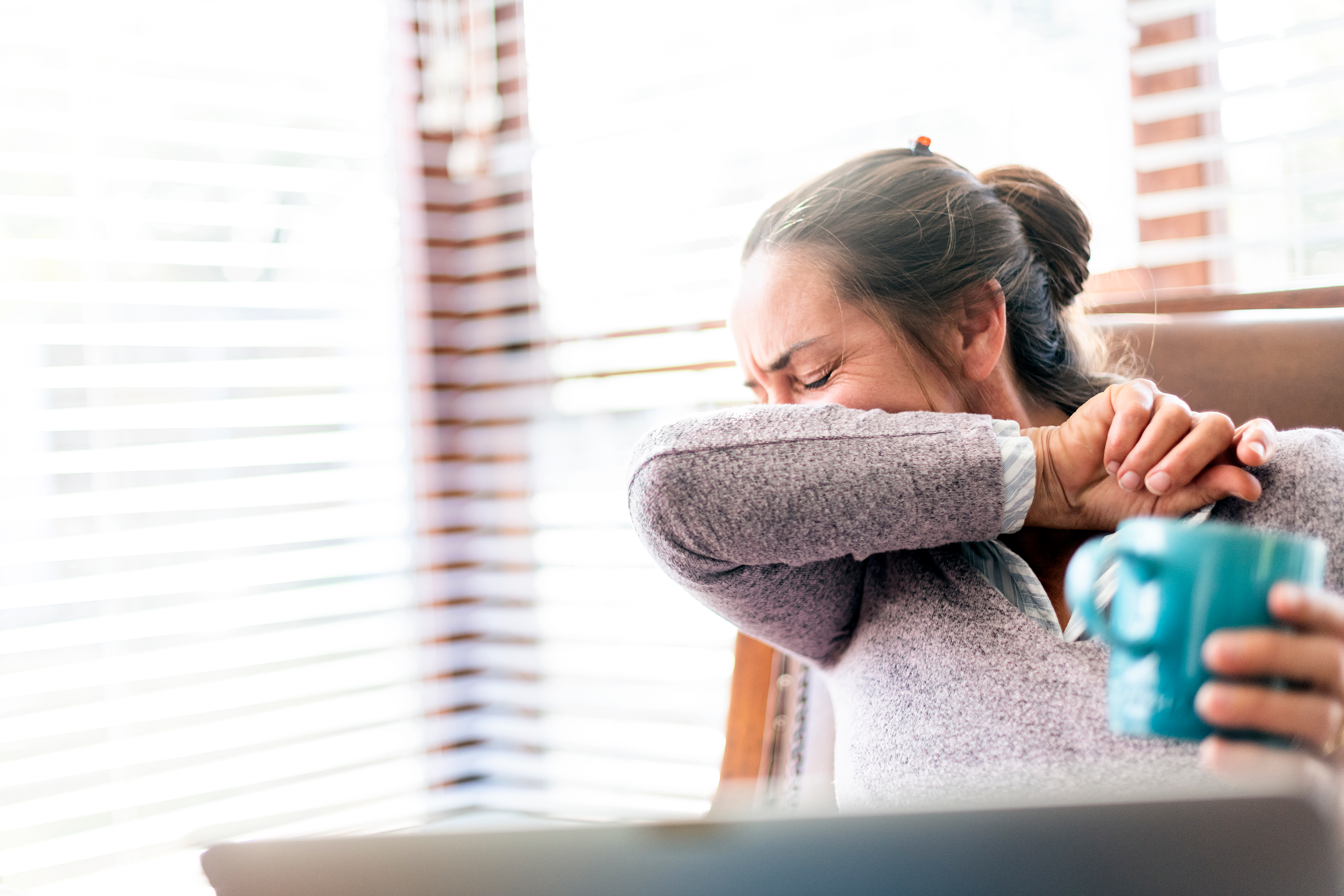 woman coughing - when to get tested for covid