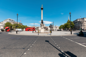 lockdown in England working, red buses going round empty Trafalgar Square