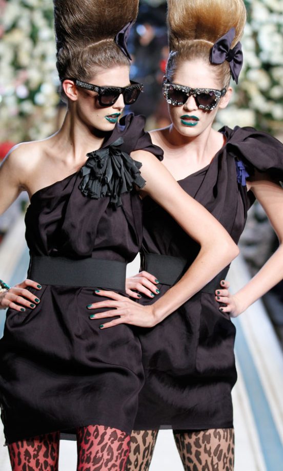 Models Wearing Belted Black One Shoulder Party Dresses With Bright Green Lips At The Lanvin For H&M Haute Couture New York Fashion Show 2010