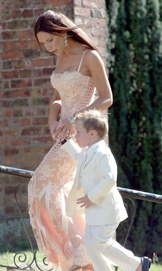 Victoria Beckham, With Her Son Brooklyn, Wearing A Peach Lace Dress At The Wedding Of Her Friend Davinia Taylor, July 2003