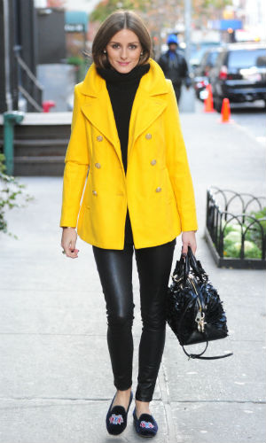 Olivia Palermo wearing a bright yellow peacoat over an all black outfit in New York