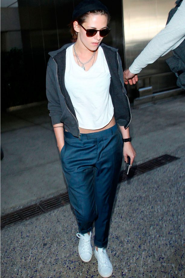 Kristen Stewart Keeps A Low Profile In Blue Tapered Trousers And Grey Hoodie At LAX Airport, 2015